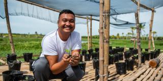 Volunteer holding seedling