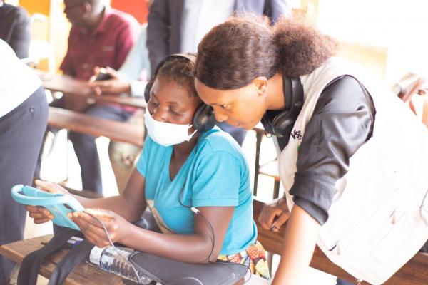 Volunteer helps woman with tablet