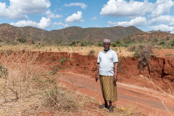 Man stands field where crops have been destroyed by drought